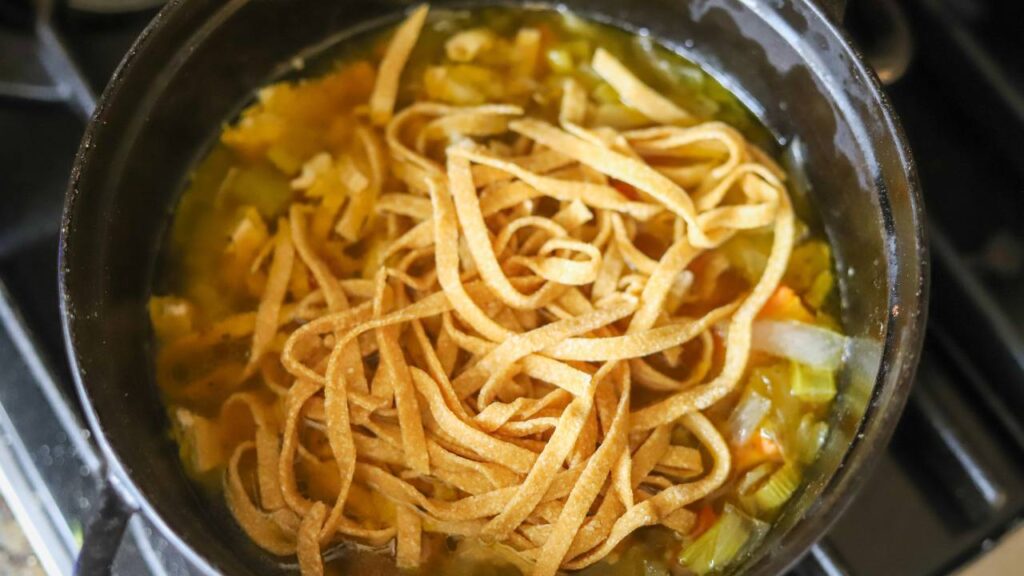 Fresh whole grain pasta cooking in pot of soup