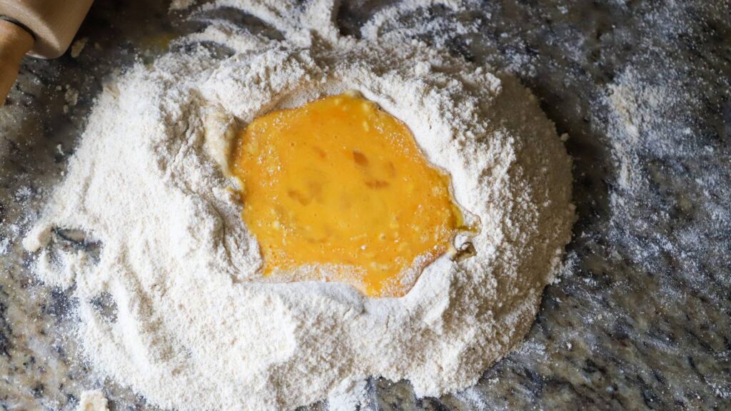 Flour well with eggs for from scratch whole wheat pasta dough