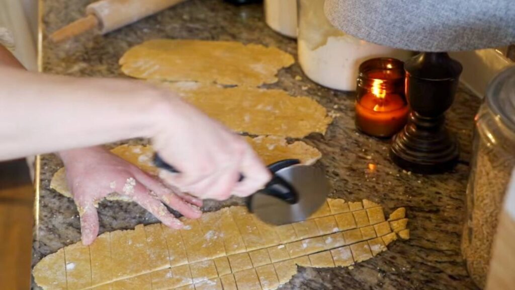 Cutting homemade whole grain pasta dough into noodles on countertop