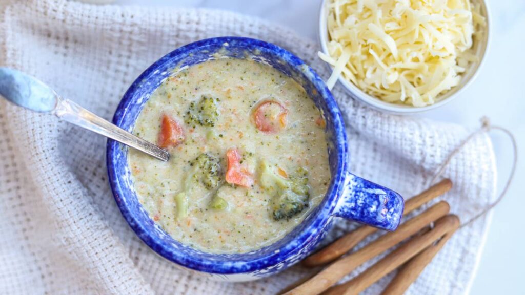 Bowl of homemade healthy broccoli cheddar soup with cheddar cheese