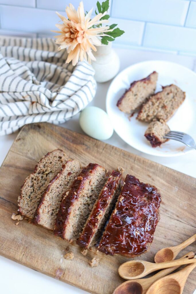 Sliced homemade meatloaf with ketchup glaze on cutting board