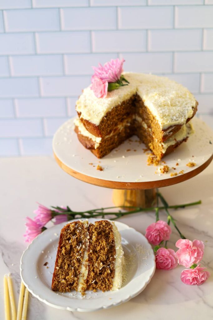 Einkorn coconut almond cake with cream cheese frosting on cake stand