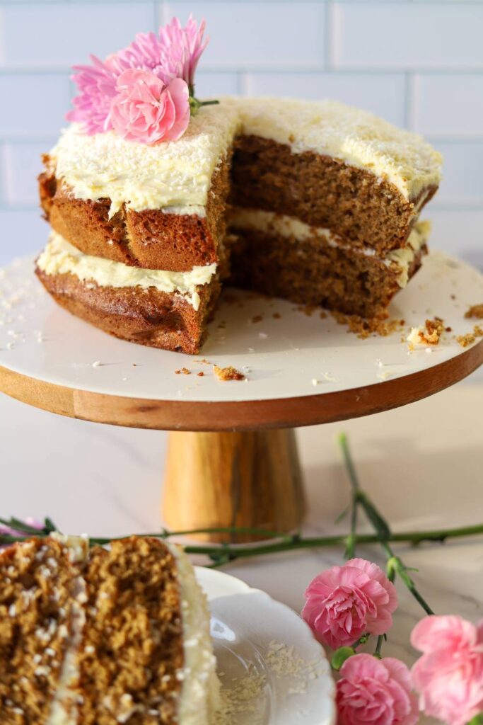 Einkorn coconut almond cake with cream cheese frosting on cake stand