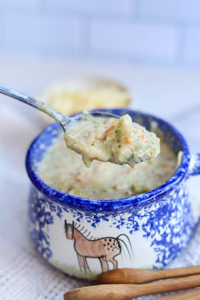 Spoonful of healthy broccoli cheddar soup over bowl