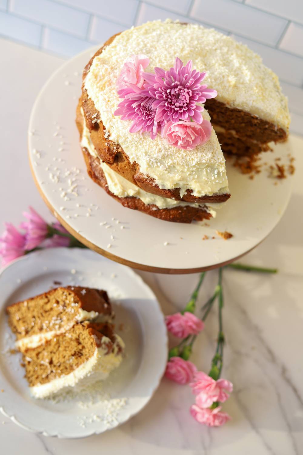 Einkorn coconut almond cake with cream cheese frosting and slice on plate