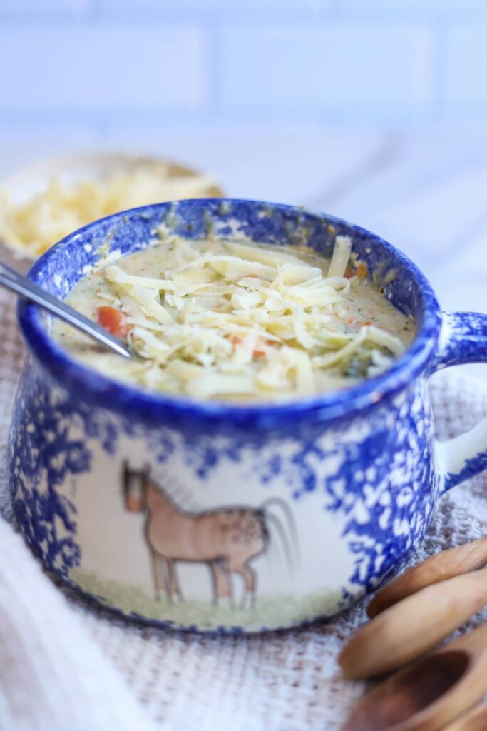 Healthy broccoli cheddar soup topped with shredded cheese