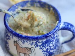 Spoon lifting creamy broccoli cheddar soup from bowl