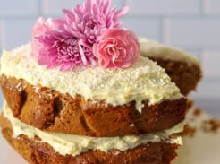 Frosted einkorn coconut almond cake with flowers on top