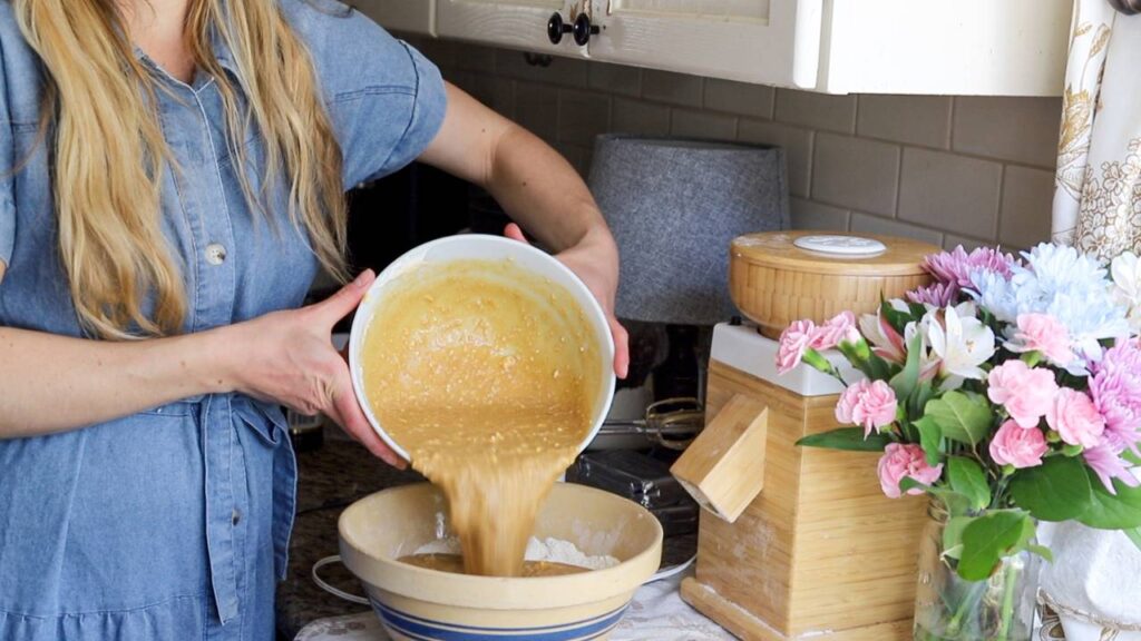Pouring cake batter into mixing bowl for einkorn cake