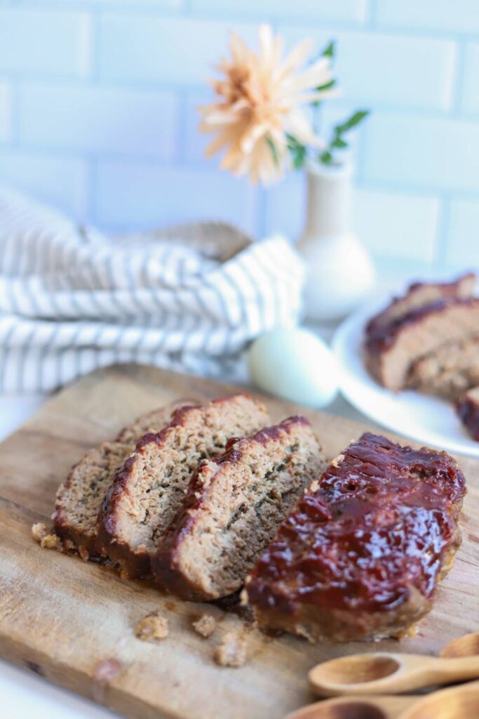 Homemade meatloaf slices on wooden cutting board