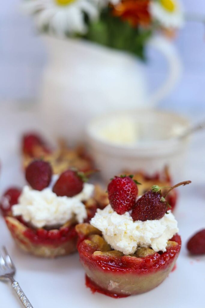 Mini strawberry pies topped with whipped cream and fresh strawberries