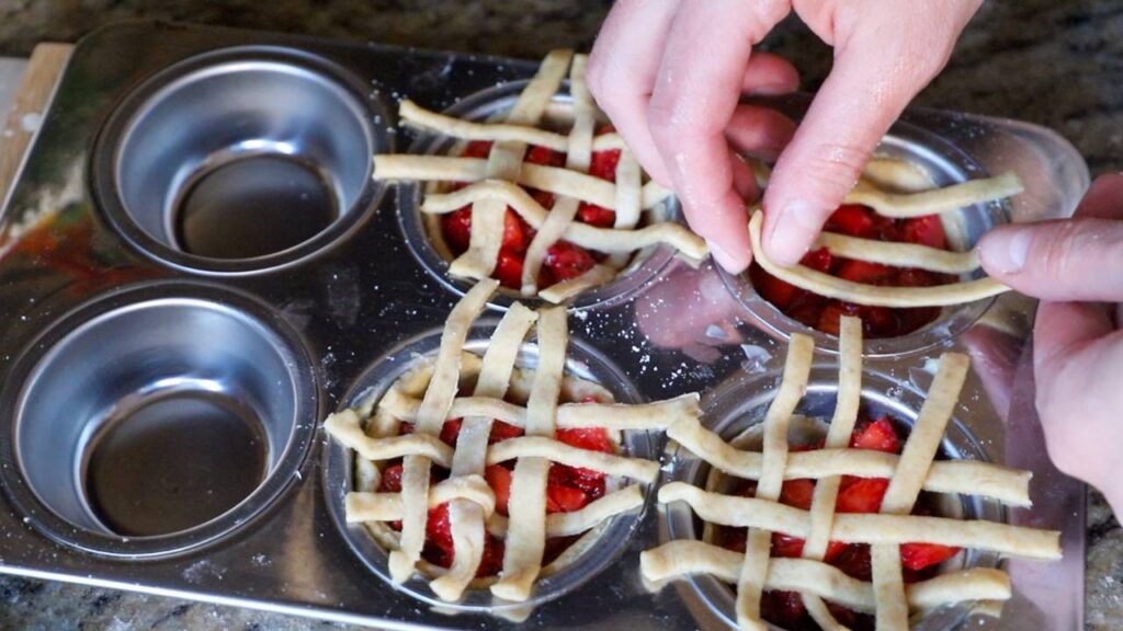 Adding lattice pie crust to homemade mini strawberry pies