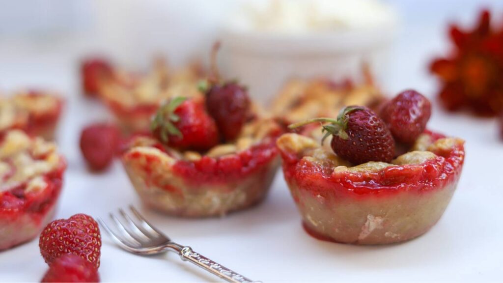 Homemade mini strawberry pies with fresh strawberries and whipped cream