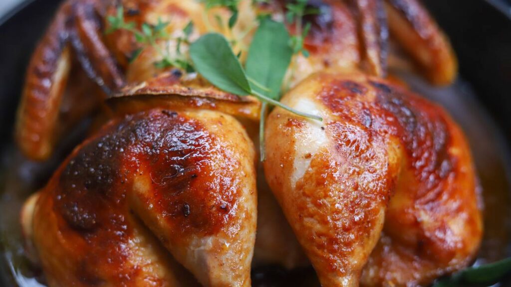 Close-up of crispy maple BBQ spatchcock chicken with caramelized skin.