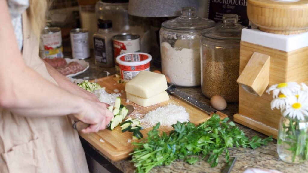 Chopping zucchini and preparing ingredients for homemade cottage cheese lasagna.