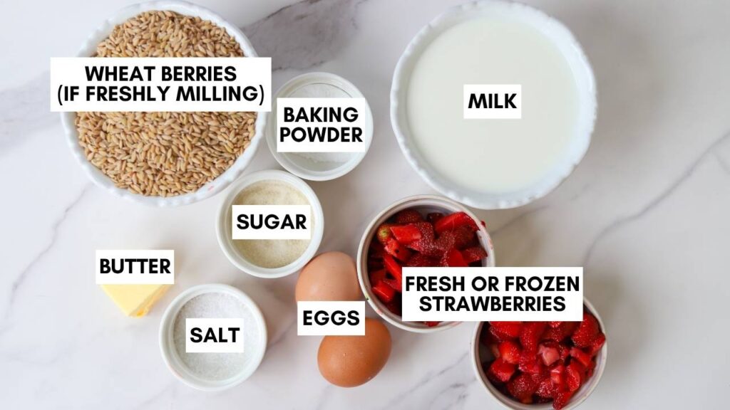 Ingredients for whole grain einkorn strawberry pancakes with freshly milled flour and fresh strawberries.