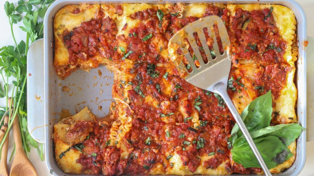 Homemade cottage cheese lasagna with one serving removed from the baking dish.