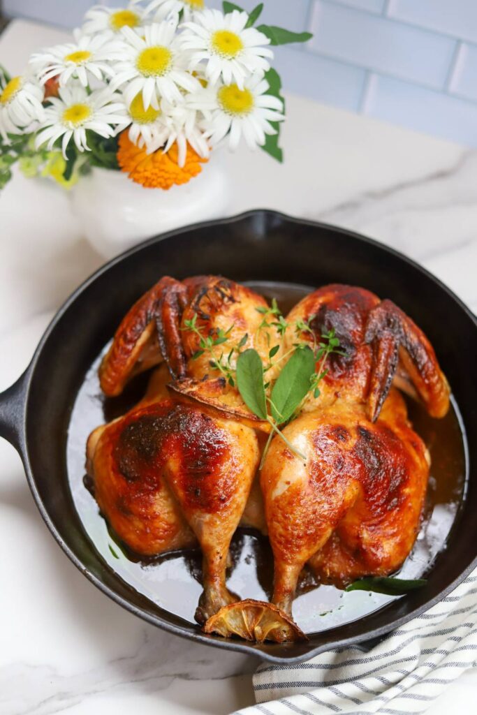 Close-up of maple BBQ spatchcock chicken in a cast iron skillet.