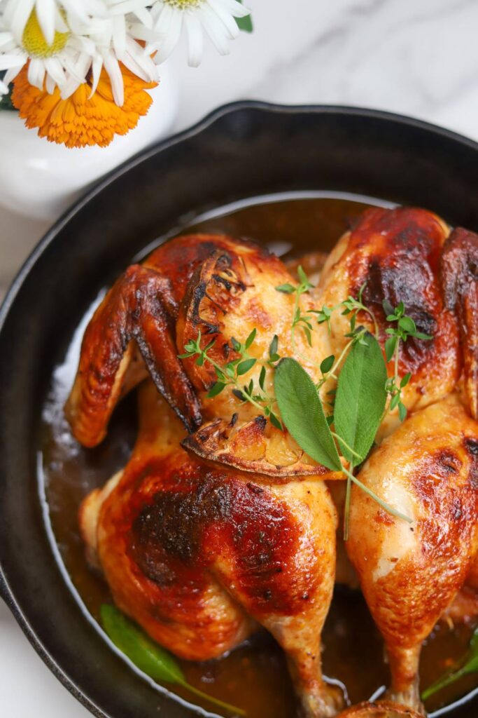 Maple BBQ spatchcock chicken served in a cast iron skillet.