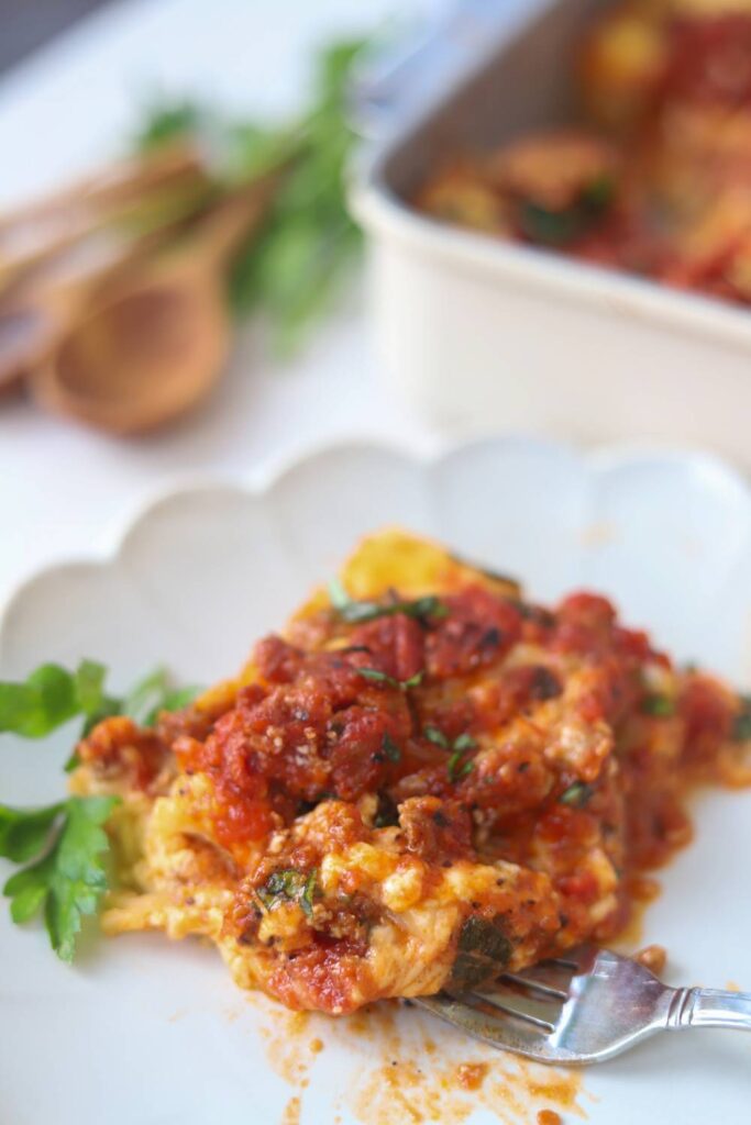 Slice of homemade cottage cheese lasagna served on a white plate.