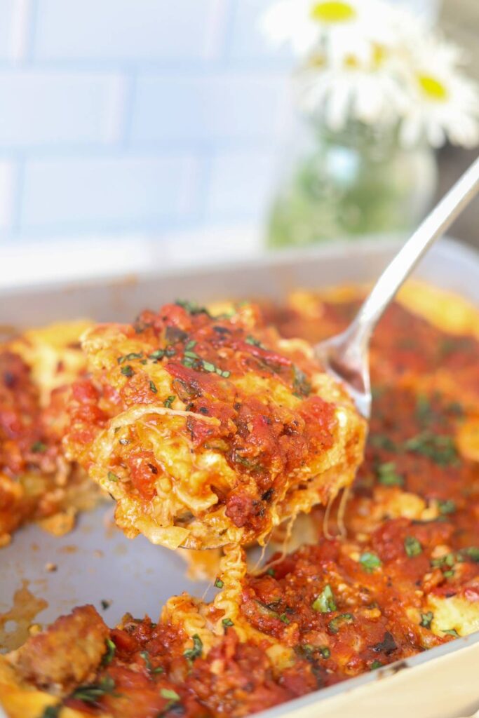Serving a slice of homemade cottage cheese lasagna with a spatula.