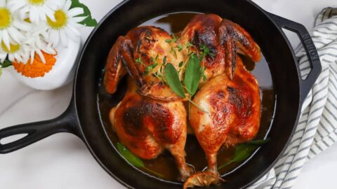 Overhead view of maple BBQ spatchcock chicken in a cast iron skillet.
