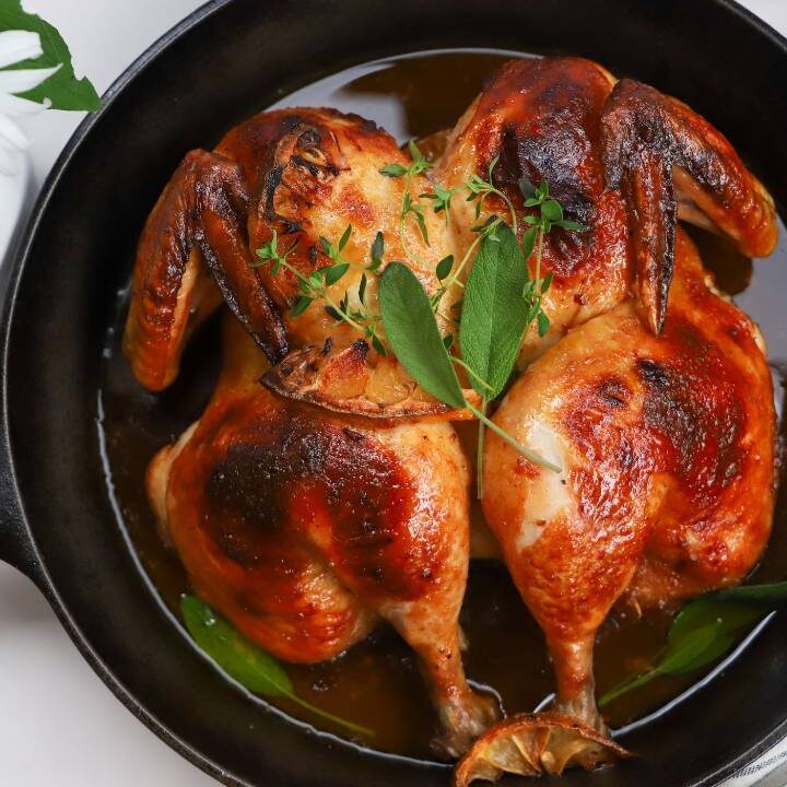 Overhead view of maple BBQ spatchcock chicken in a cast iron skillet.