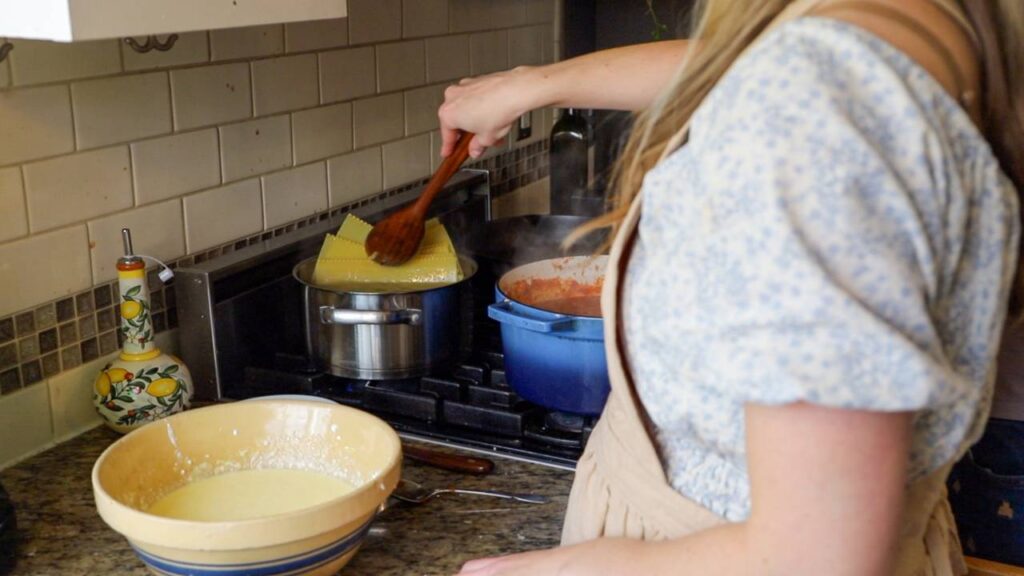 Boiling lasagna noodles while preparing homemade cottage cheese lasagna.