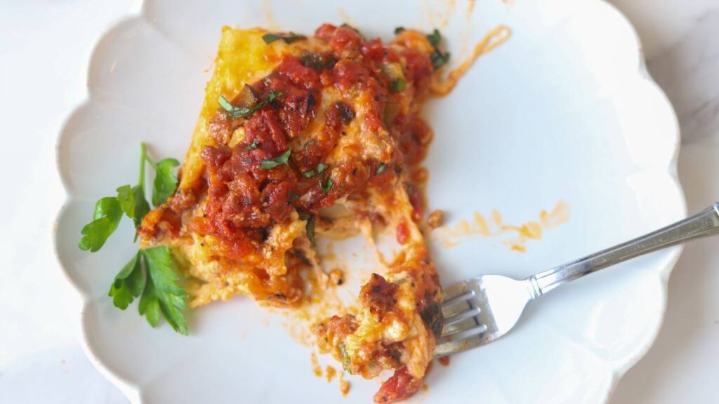 Slice of homemade cottage cheese lasagna served on a white plate.