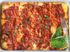 Homemade cottage cheese lasagna baked until bubbly and topped with fresh basil.