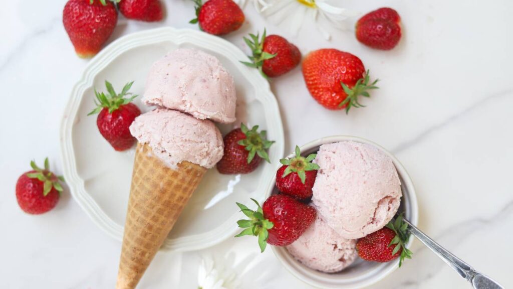 Homemade strawberry ice cream served with fresh strawberries