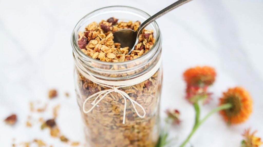 Jar of pumpkin spice granola with a spoon
