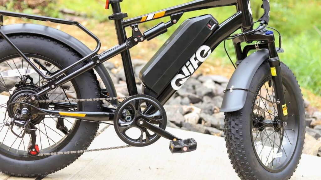 Close-up of the Qlife Racer electric bike frame, battery, and pedals