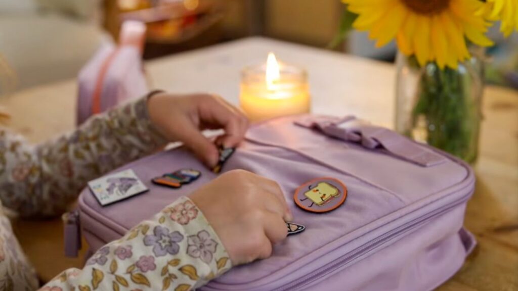 Child decorating a backpack with patches