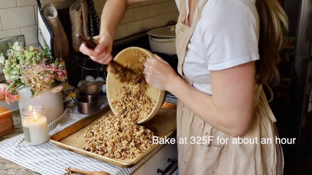 Granola mixture being spread onto a baking sheet
