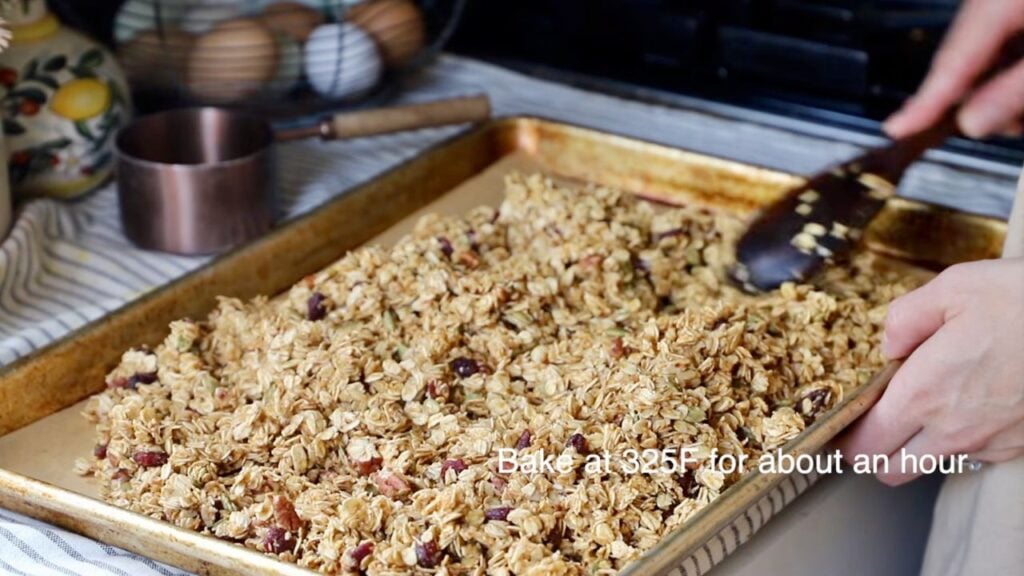 Pumpkin spice granola spread on a baking sheet before baking