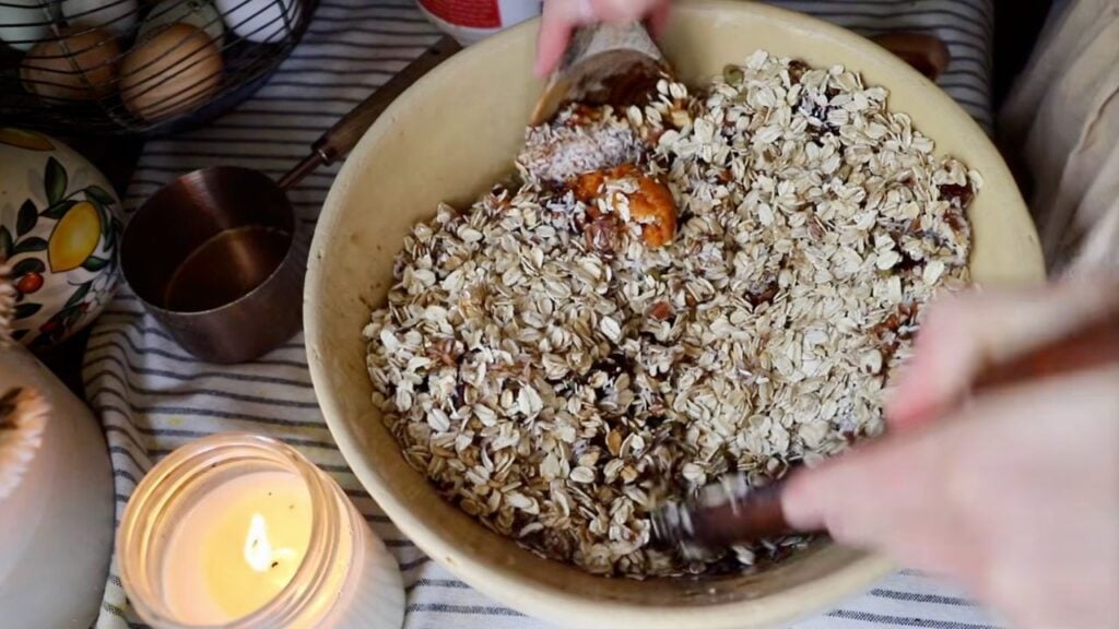 Ingredients being mixed together in a large bowl for homemade granola