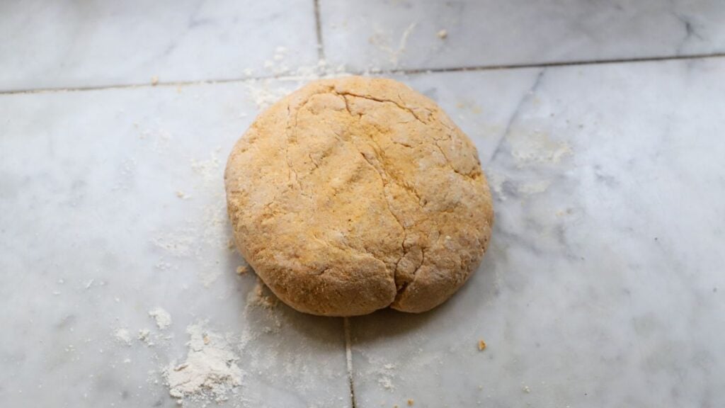 Homemade pumpkin gnocchi dough on a kitchen counter.
