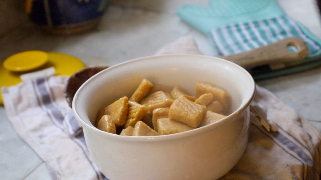 Homemade pumpkin gnocchi in a white bowl.