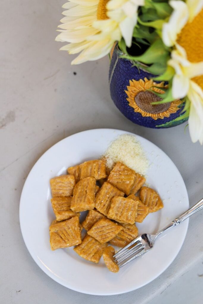 Homemade pumpkin gnocchi in a white bowl.