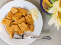 Cooked pumpkin gnocchi served with grated Parmesan cheese.
