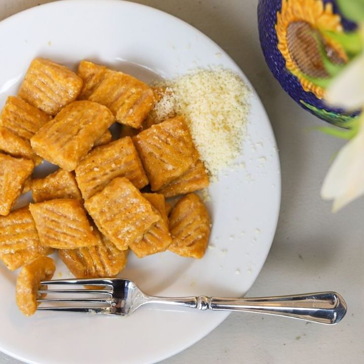 Cooked pumpkin gnocchi served with grated Parmesan cheese.