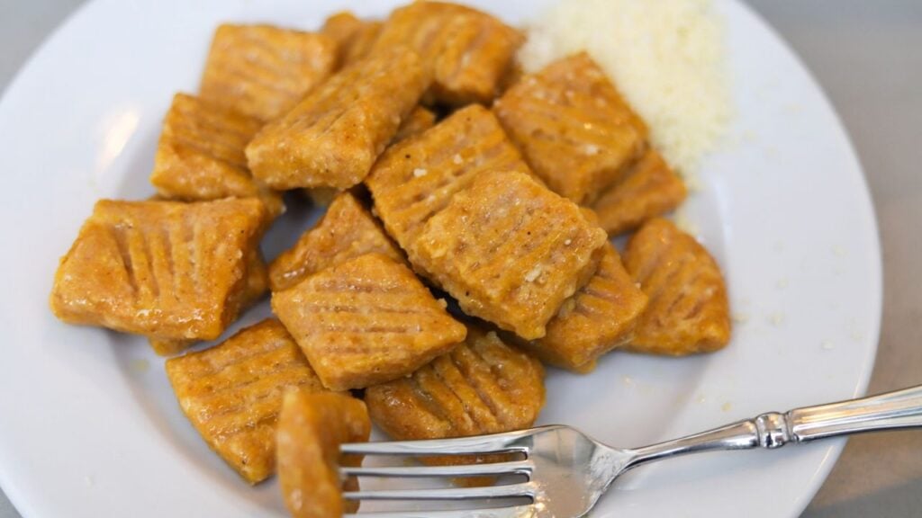 Pumpkin gnocchi served with grated Parmesan cheese.