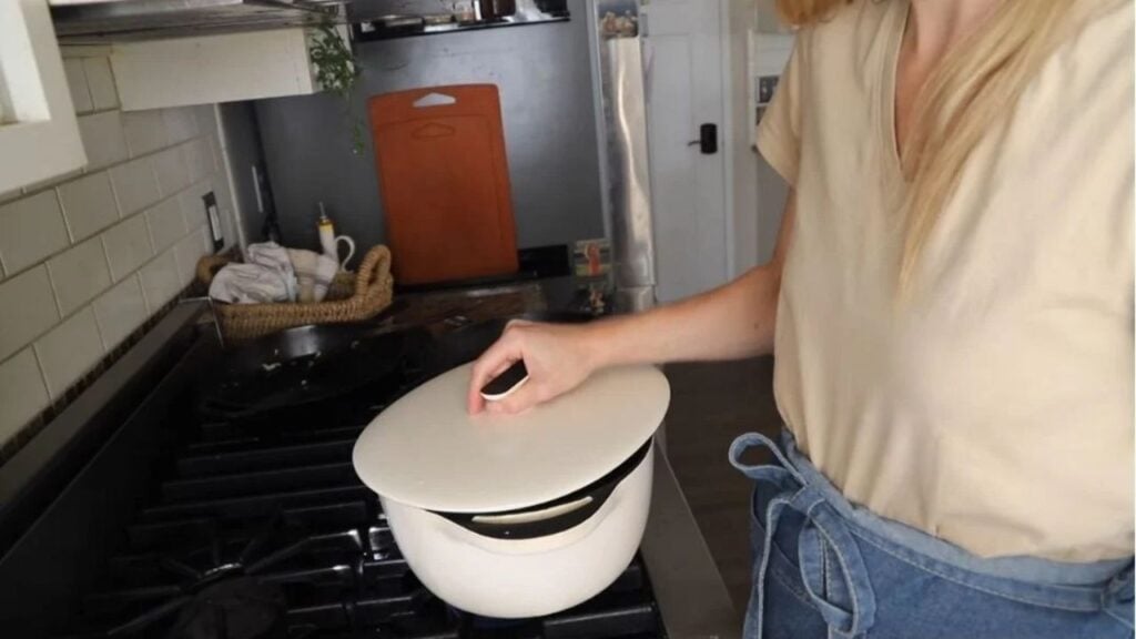 White Dutch oven simmering a homemade meal on the stovetop.
