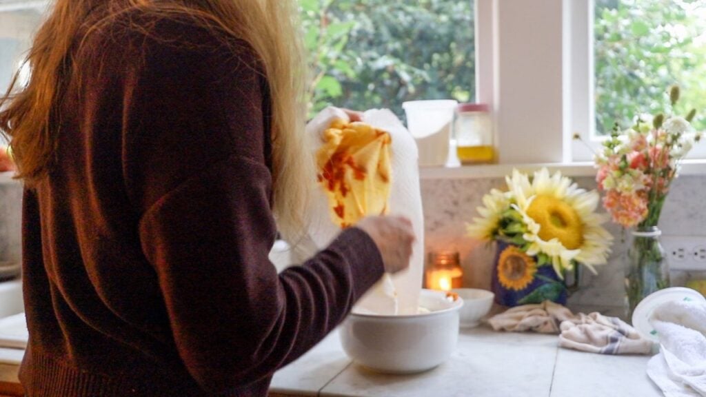 Mixing pumpkin gnocchi ingredients in a white bowl.