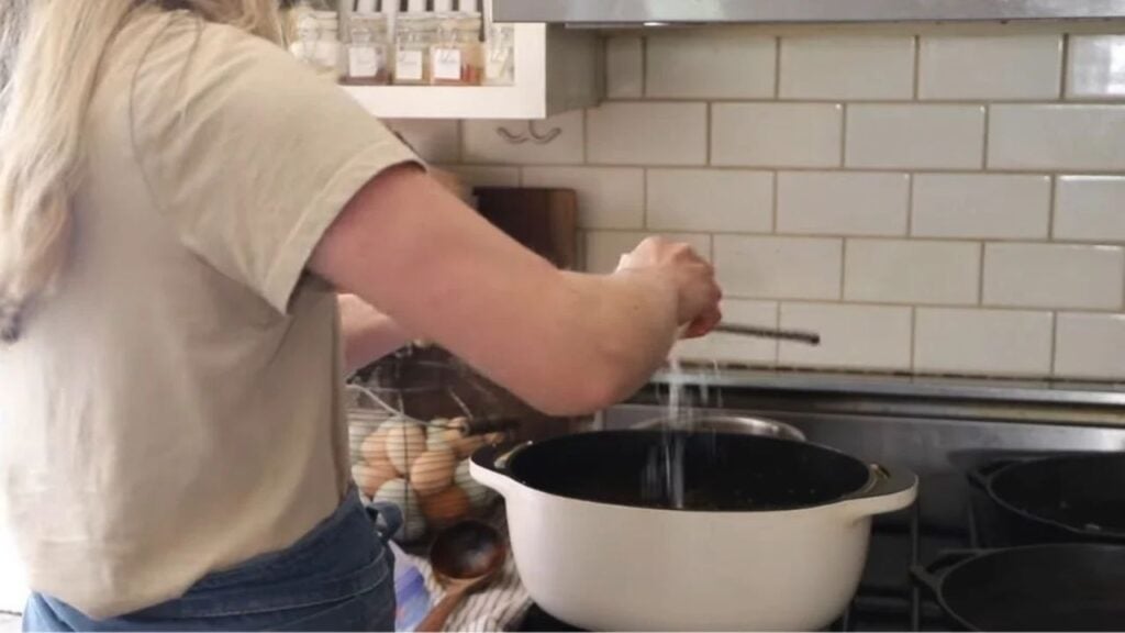 Freshly grated parmesan cheese using a handheld cheese shredder.